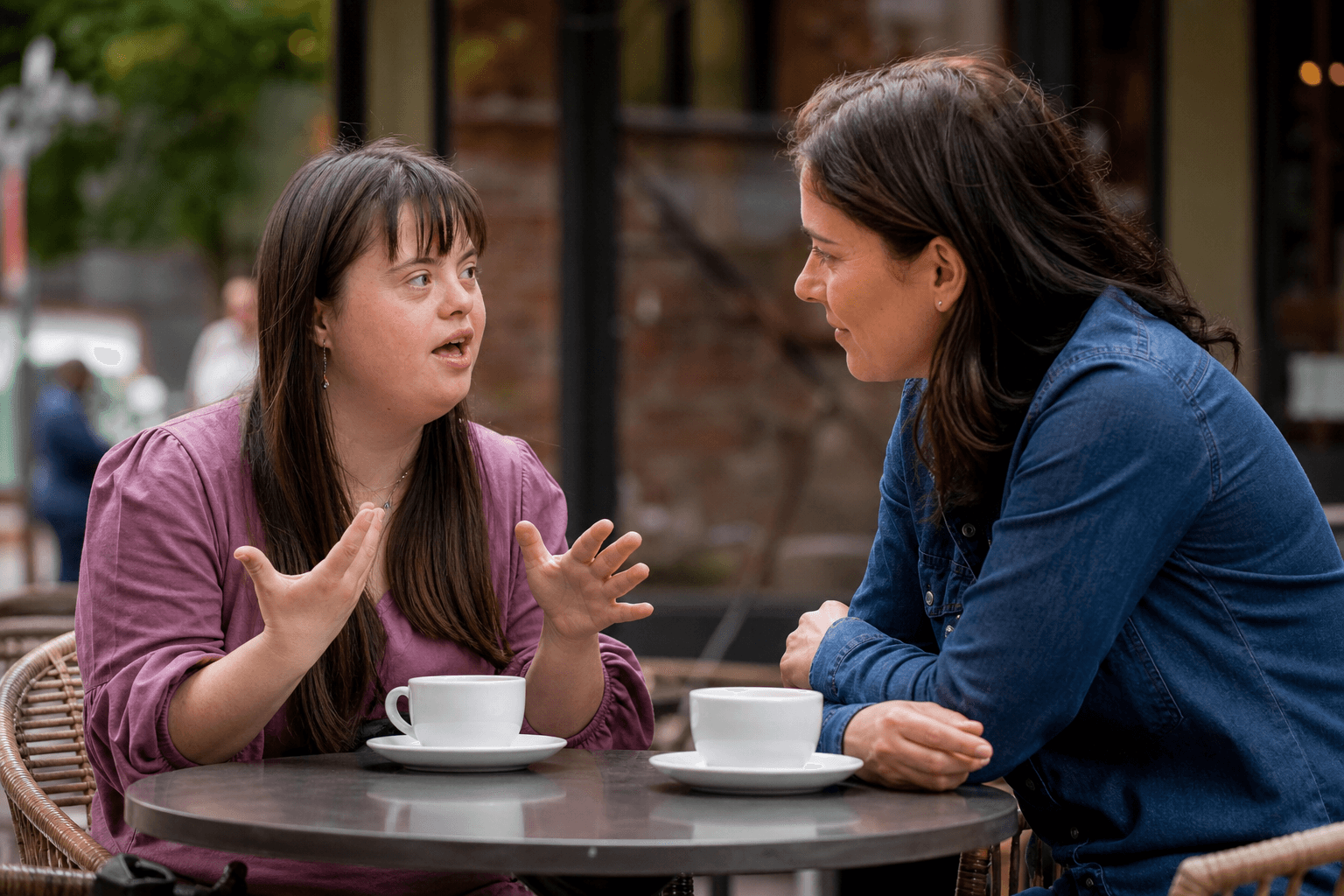 An animated conversation between two adults at an outdoor cafe, one expressing herself confidently with hand gestures.