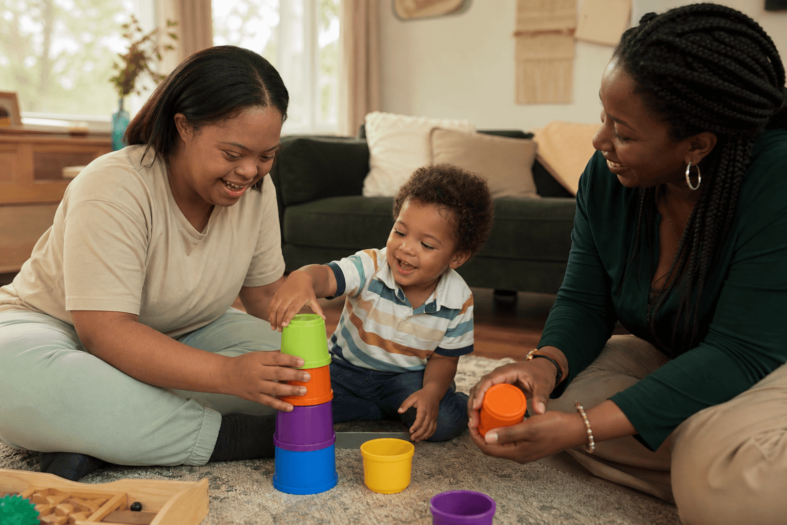 A Black mother with Down syndrome plays with her toddler while a parenting coach supports them at home.